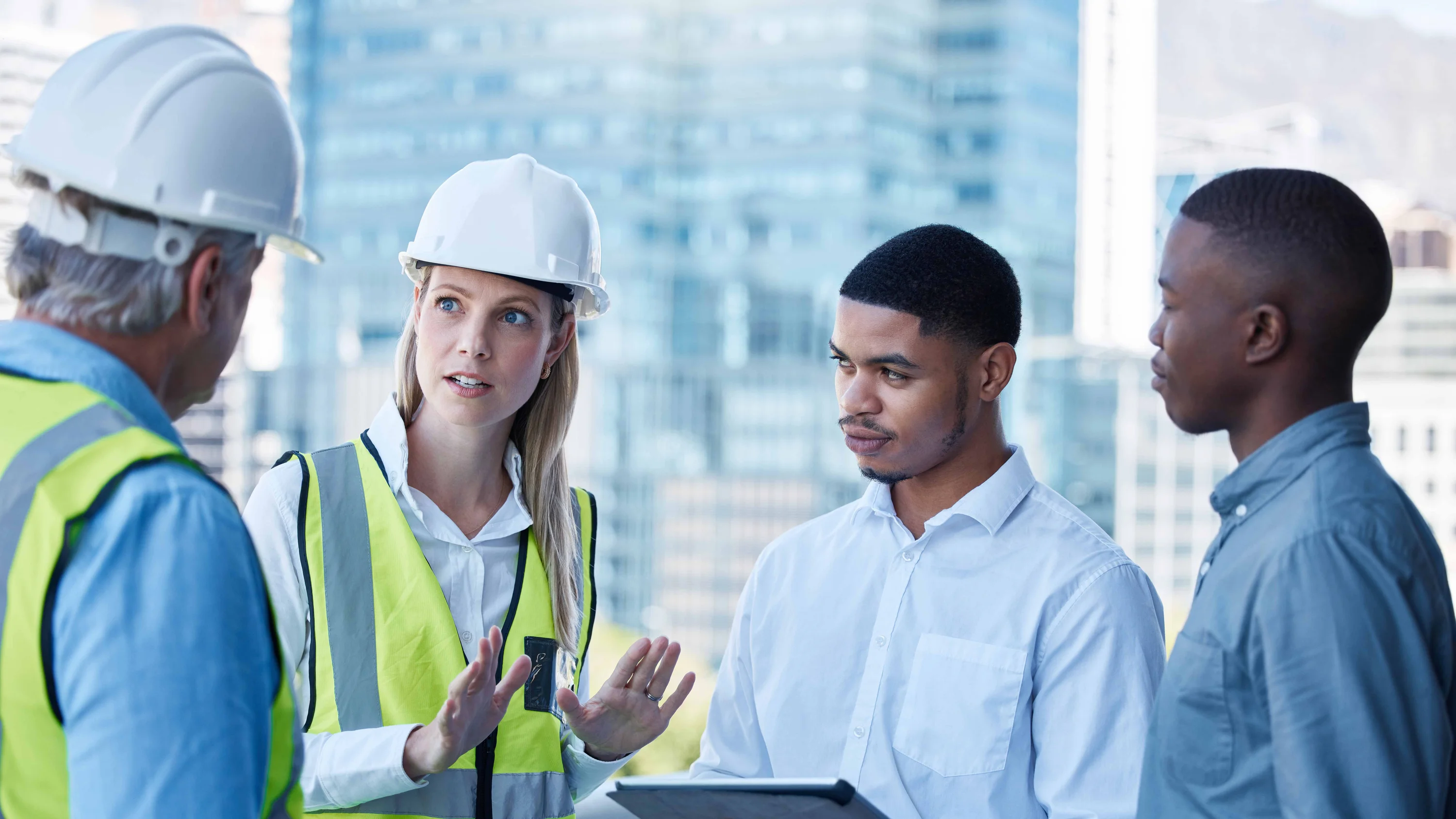 A group of individuals in safety equipment having a conversation.