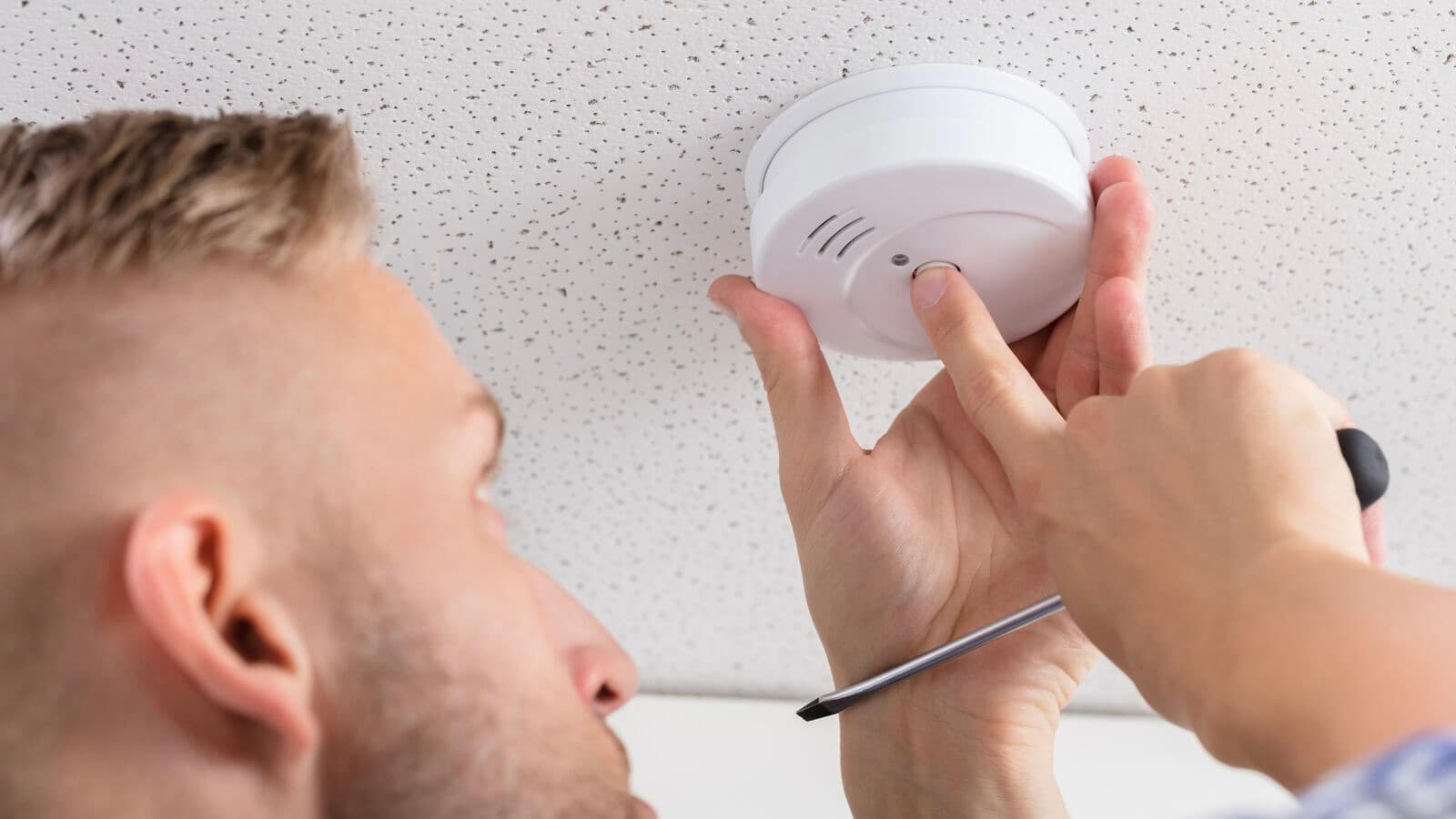 A man testing his CO detector
