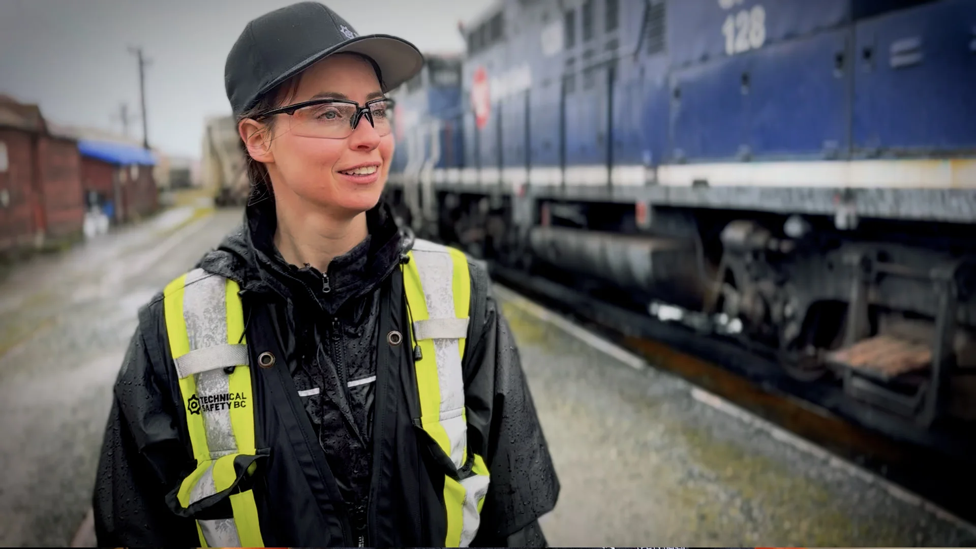 A technical safety employee wearing safety equipment standing next to a train.