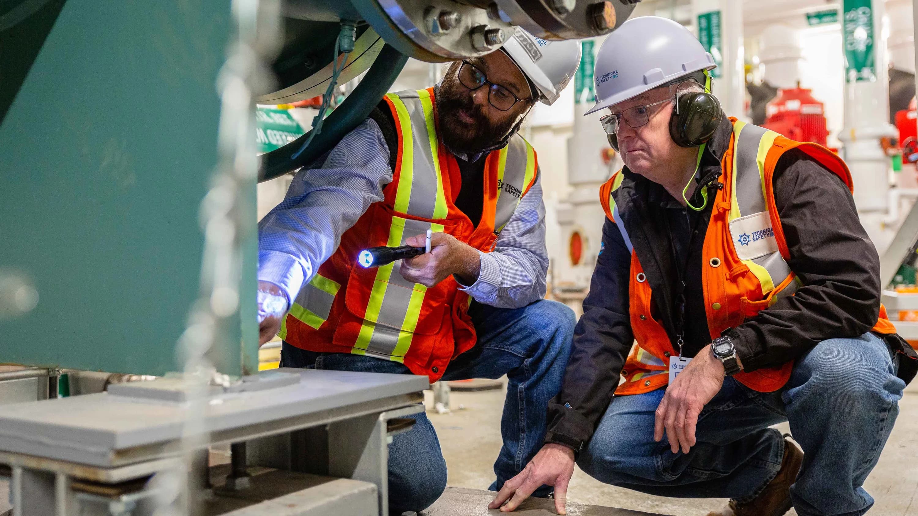 Two Technical Safety BC employees inspecting a piece of equipment.