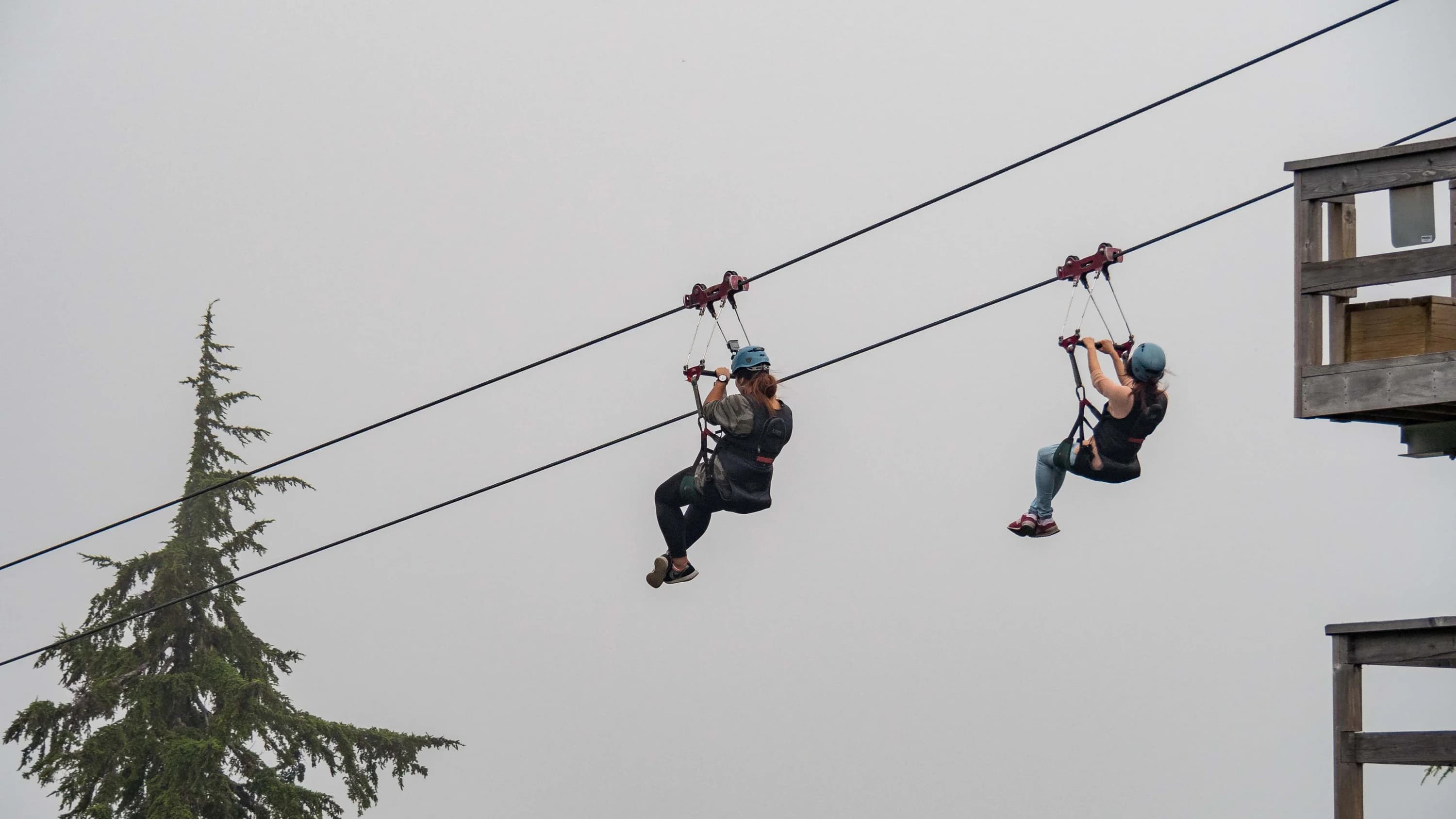 Two women riding a zipline